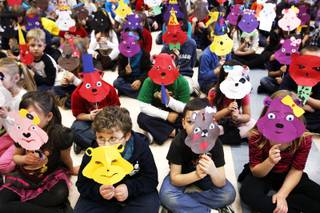 Students at Twitchell Elementary School display the bear masks they made after a workshop with Ron and Marsha Feller at their school in Henderson Friday, Ja. 20, 2012.