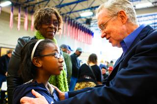 Sen. Harry Reid speaks with 10-year-old Aquilla El-Amin as her friend, Betty Carter, smiles beside her while attending the 2012 Democratic Caucus Saturday, Jan. 21, 2012, at Cheyenne High School.
