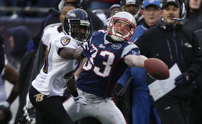 New England Patriot Wes Welker (83) stretches for the ball as Baltimore Ravens Lardarius Webb (21) runs in to block the catch during the first half of the AFC Championship NFL football game, Sunday, Jan. 22, 2012, in Foxborough, Mass.)
