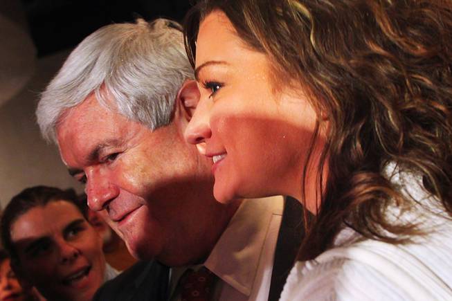 Republican presidential candidate Newt Gingrich has his photo taken with a woman who had just identified herself as being with the Occupy movement after speaking at a town hall-style meeting with business and community leaders from the Las Vegas Latino community Thursday, Feb. 2, 2012. 