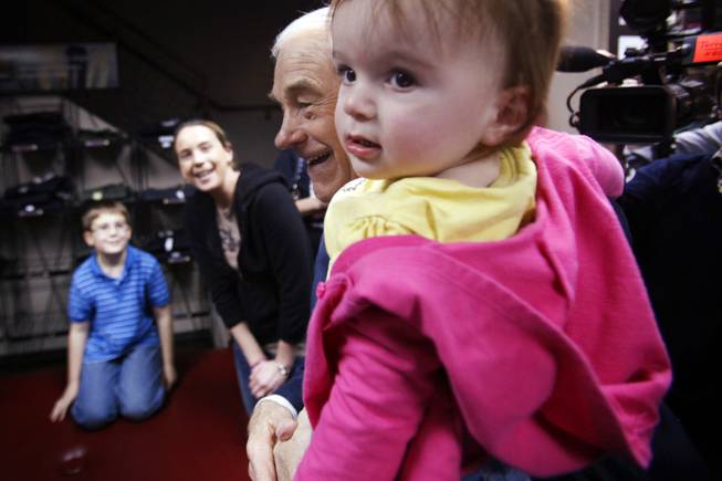 Rep. Ron Paul poses with a baby while campaigning at American Shooters, an indoor gun range and retail store in Las Vegas Friday, Feb. 3, 2012.