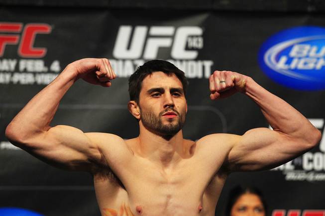Carlos Condit flexes after making weight during the weigh in for UFC 143 Friday, Feb. 3, 2012 at Mandalay Bay.