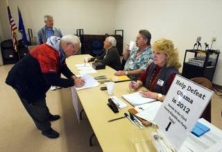 Roy L. Phillips, left, of Cal-Nev-Ari, signs-in for a Republican caucus at a community center in Searchlight Saturday, February 4, 2012.