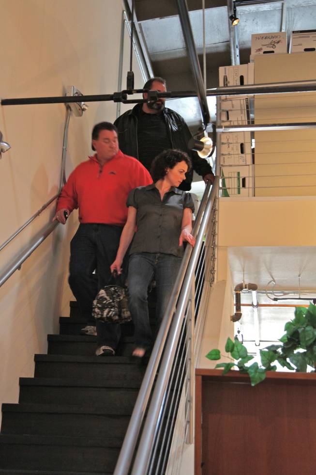 Outgoing Nevada State GOP chairwoman Amy Tarkanian and State GOP chair hopeful Michael McDonald descend the stairs from a meeting with campaign representatives Sunday morning. They take a look at the caucus ballot counting going on below as they come downstairs. David McGowan, Rick Santorum's campaign director, comes down the stairs behind them.