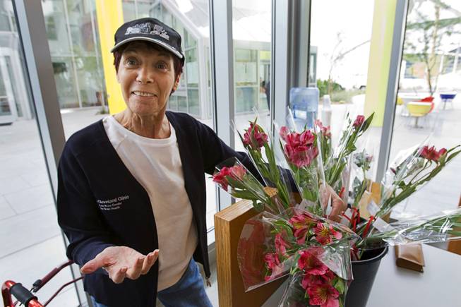 Volunteer Lydia Woltag, 66, stands by flowers at the Cleveland Clinic Lou Ruvo Center for Brain Health Tuesday, February 7, 2012. In addition to helping brighten their day, the flowers help remind patients with Alzheimer's disease of the center. Patients remember that the center is the place where they get a flower, a volunteer said.