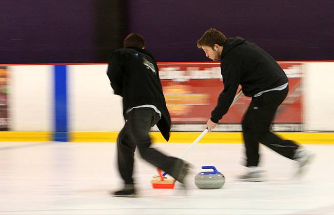 Kyle Volin, left and Zachary Clayton sweep in front of a stone during an open practice session of the Las Vegas Curling Club at the Las Vegas Ice Center on West Flamingo Road Sunday, Feb 12, 2012. Sweeping allows the stone to travel farther and gives a degree of directional control.