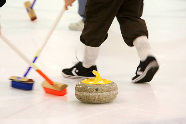 Curling students sweep in front of a stone during a practice session of the Las Vegas Curling Club at the Las Vegas Ice Center on West Flamingo Road on Feb 12, 2012. Sweeping allows the stone to travel farther and gives a degree of directional control.
