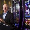 Richard Haddrill, CEO of Bally Technologies, poses by a Michael Jackson-themed slot machine Monday, March 5, 2012.
