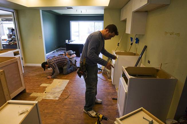 Homeowner Mike Lopez works on his kitchen floor as Giovanni ...
