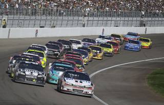 Tony Stewart (14) leads coming out of a restart during the NASCAR Sprint Cup Series auto race, Sunday, March 11, 2012, in Las Vegas. 