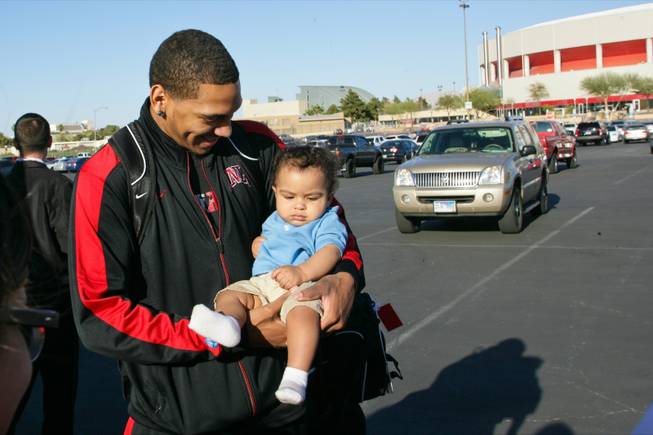 UNLV's Anthony Marshall takes a photo with a young Rebel fan before boarding a bus to Albuquerque for the NCAA Tournament, Tuesday March, 13 2012.