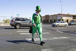 Metro Officer Mike Lemley, dressed as a Leprechaun, crosses Arvillle Street at Sirius Avenue during a pedestrian safety awareness event Tuesday, March 13, 2012.
