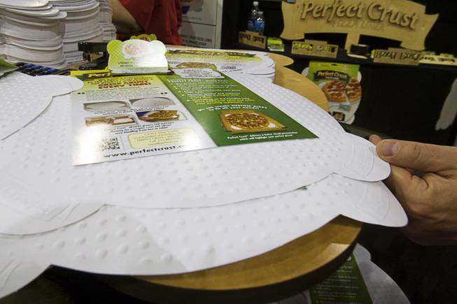 The Perfect Crust Pizza Liner is displayed during the International Pizza Expo at the Las Vegas Convention Center Wednesday, March 14, 2012. The special paper liner absorbs excess oil and is embossed to keep the crust slightly elevated over the paper, keeping the crust crisp in the delivery box.
