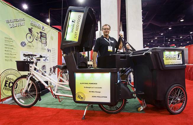 Tom Casey, president of Thrust Electric Bikes, stands behind a pizza delivery bike during the International Pizza Expo at the Las Vegas Convention Center Wednesday, March 14, 2012. The bike comes equipped with a delivery container and graphics and LED lighting. An optional trailer can be used for more delivery storage or as a food vending station.