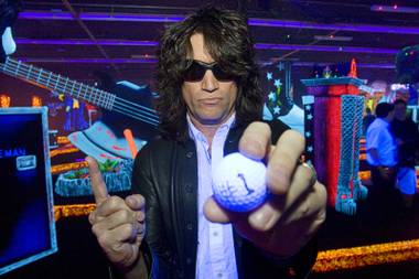 Kiss band member Tommy Thayer poses with his ball after hitting a hole in one on his first try during the grand opening of Kiss by Monster Mini Golf at 4503 Paradise Road Thursday, March 15, 2012.