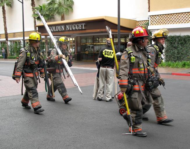 Las Vegas firefighters prepare to leave the scene of a fire Thursday morning at the Golden Nugget. A fire in the room on the 22nd floor of the Rush Tower sent an unidentified man to the hospital in critical condition.