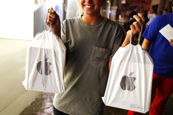 A happy customer holds up bags with her new iPads at the Apple Store inside the Forum Shops at Caesars in Las Vegas on Friday, March 16, 2012.
