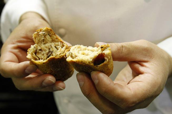 Owner Carlos Pereira breaks apart a multigrain, cranberry roll at Bon Breads, a wholesale artisan bakery, Thursday, April 19, 2012.