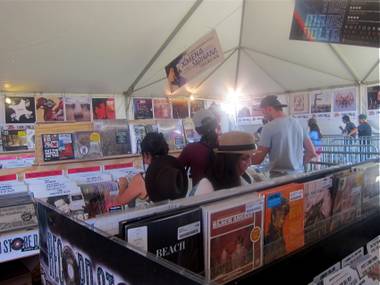 Patrons peruse Zia Records’ Record Store Day offerings at the store’s pop-up shop at the Coachella Valley Music and Arts Festival on Saturday, April 21, 2012.