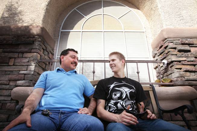 Matthew Pitzer, right, 18, sits with Manny Solario at Solario's home in Las Vegas on Friday, April 27, 2012. Pitzer was 12 when he walked into Solario's special education class; today he calls Solario "dad."