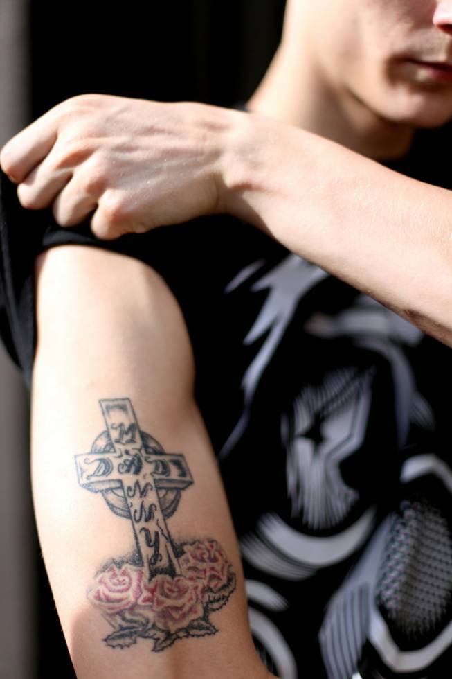 Matthew Pitzer, 18, shows the tattoo on his arm, the name Manny Solario, whom he calls "dad," in Las Vegas on Friday, April 27, 2012.
