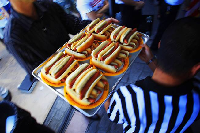 A tray of hot dogs is taken to the table ...