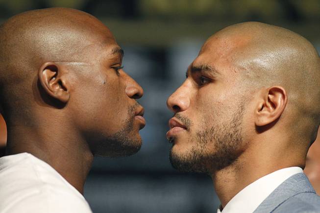 Undefeated boxer Floyd Mayweather Jr. and WBA super welterweight champion Miguel Cotto of Puerto Rico face off at a news conference at the MGM Grand Wednesday, May 2, 2012. Mayweather will challenge Cotto for the title at the MGM Grand Garden Arena on Saturday.