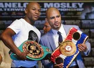 Undefeated boxer Floyd Mayweather Jr. and WBA super welterweight champion Miguel Cotto of Puerto Rico pose during a news conference at the MGM Grand Wednesday, May 2, 2012. Mayweather will challenge Cotto for the title at the MGM Grand Garden Arena on Saturday.