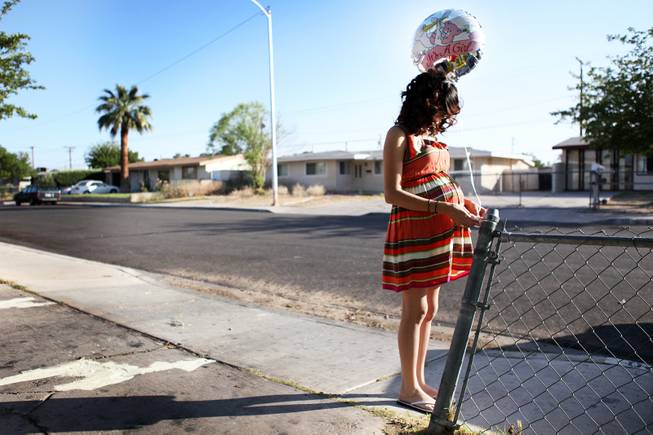 Evaleen Diaz ties a balloon at the end of her driveway during her baby shower at her home in Las Vegas on Saturday, May 5, 2012.