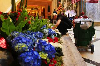 A horticulturist works on a bed of flowers at the Palazzo. Indoor floral gardens and displays draping behind registration desks have become centerpieces defining beauty at resorts along the Strip.