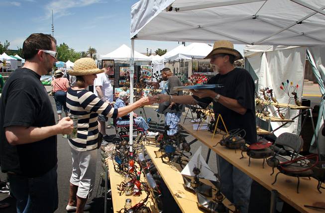 Jeffrey Newmark of Laughlin sells one of his Garden Critters, animal sculptures made from wire, stones and other materials, to
a customer at the Art Festival of Henderson on Saturday, May 12, 2012.