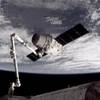 This image provided by NASA-TV shows the SpaceX Dragon commercial cargo craft, top, after Dragon was grappled by the Canadarm2 robotic arm and connected to the International Space Station, Friday, May 25, 2012. Dragon is scheduled to spend about a week docked with the station before returning to Earth on May 31 for retrieval.