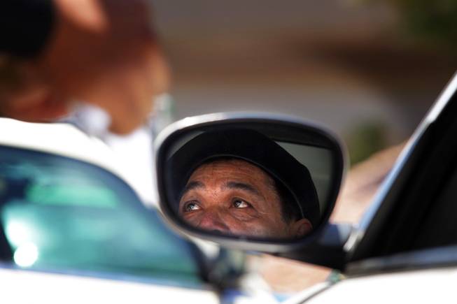 A taxi driver looks concerned at a Taxicab Authority Police long haul checkpoint near the entrance to the airport tunnel exiting McCarran International Airport in Las Vegas on Friday, June 8, 2012. The driver did not get a ticket.