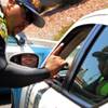 Taxicab Authority Police Investigator II L. Walker talks to a taxi driver at a long haul checkpoint near the entrance to the airport tunnel exiting McCarran International Airport in Las Vegas on Friday, June 8, 2012. The driver did not get a ticket.