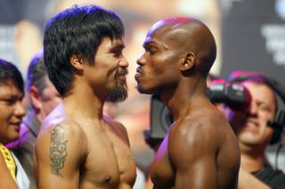 Filipino boxer Manny Pacquiao, left, and Timothy Bradley Jr. face off during an official weigh-in at the MGM Grand Garden Arena Friday, June 8, 2012. Pacquiao will defend his WBO welterweight title against the undefeated Bradley at the arena on Saturday.