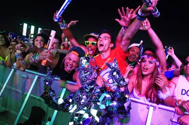Festival goers pose for a photo with a man wearing a suit of mirrors during the first night of the Electric Daisy Carnival Friday, June 8, 2012 at the Las Vegas Motor&nbsp;Speedway.