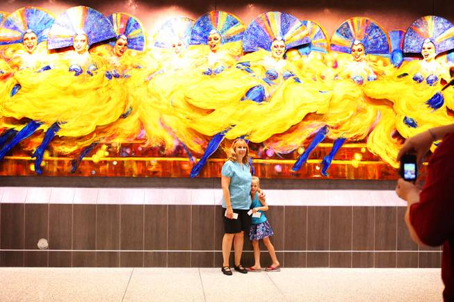 Sheila Newcomb of Las Vegas poses for a photo with her daughter Lily, 6, in the U.S. Customs and Border Protection area during an open house at the new Terminal 3 at McCarran International Airport in Las Vegas on Saturday, June 9, 2012. Terry Ritter's "Folies in Flight" artwork is seen in the background.