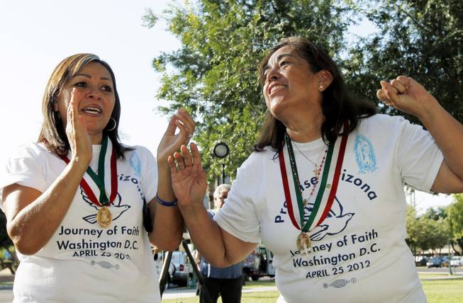 Maria Durand, left, and Rosa Maria Soto, both from Arizona, cheer as the U.S. Supreme Court decision regarding Arizona's controversial immigration law, SB1070, comes down at the Arizona Capitol on Monday, June 25, 2012, in Phoenix. The Supreme Court struck down key provisions of Arizona’s crackdown on immigrants Monday but said a much-debated portion on checking suspects’ status could go forward.