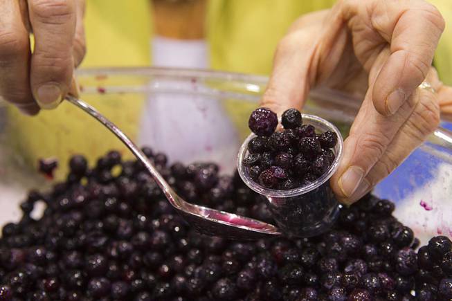Jeanne Sauve of the Wild Blueberry Association scoops a sample of wild blueberries during the IFT Food Expo at the Las Vegas Convention Center, June 25, 2012. The wild blueberries are higher in antioxident properties than farmed blueberries, she said.
