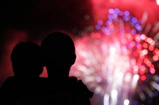 A man and child view the Independence Day fireworks on top of the Paseo Verde parking garage at Green Valley Ranch Casino in Henderson on Wednesday, July 4, 2012.