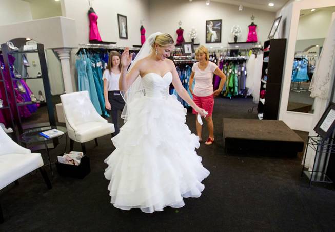 Julie Mark, 24, tests out dance moves while wearing her wedding dress as her mother and sales consultant Celia Mangione look on at Celebrations Bridal and Fashion at 3131 South Jones Boulevard Wednesday July 11, 2012. A reality television crew recently filmed at Celebrations in hopes of making a Vegas version of "Say Yes to the Dress," a reality series which follows events at Kleinfeld Bridal in New York City.