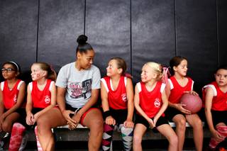 Lady Rebel Kelli Thompson sits with the 'Lil Lady Rebels under 10 team during a girls youth summer basketball league game at the Downtown Recreation Center in Henderson  on Thursday, July 12, 2012.