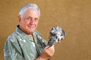 Irv Atkins poses with a piece of a B-25 Mitchell bomber at his home in Henderson on Wednesday, July 18, 2012. The artifact, from a B-25 bomber crash into the Empire State Building on July 28, 1945, was featured in a PBS TV show called 