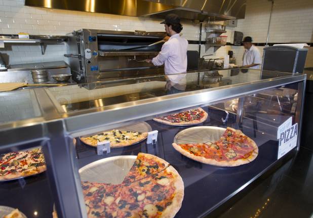 Michael Vakneen warms up a slice of pizza in the oven at Pop Up Pizza in the Plaza in downtown Las Vegas Sunday, July 22, 2012. Vakeneen is partners with Sam Cherry and Grant Garcia in the business which opened in May. STEVE MARCUS
