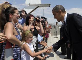 President Barack Obama greets people after arriving at the Nevada Air National Guard at Tahoe International Airport in Reno, Nev., Monday, July 23, 2012, before addressing the VFW national convention. 