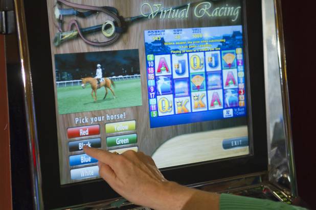 Kathy Calabro picks the black horse to win in a virtual horse race at the South Point Thursday, July 26, 2012. The South Point is the first casino in Nevada to implement the Virtual Race by Bally Technologies. The black horse won and Calabro and 106 other players, who also picked black, won $70 in bonus credits.