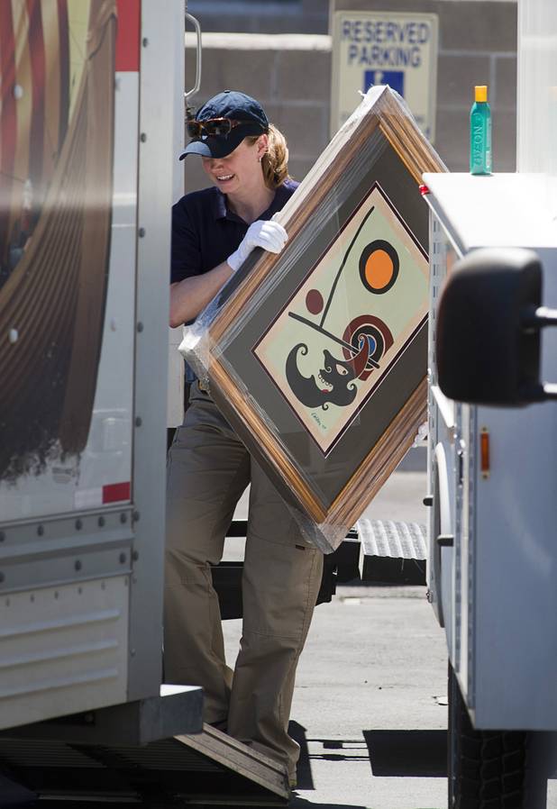 A law enforcement official carries artwork from a storage building during a seizure in Boulder City, Nevada, about 20 miles southeast of Las Vegas, July 27, 2012. The seizure is apparently related to the arrest of German fugitive Ulrich Felix Anton Engler, 51, who was arrested in the Las Vegas area on July 25. Engler is accused of bilking investors of over $100 million using an Internet pyramid scheme.