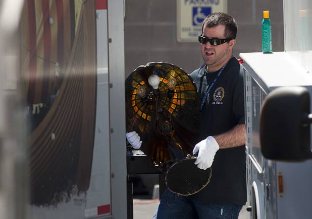 An FBI agent carries a lamp from a storage building during a seizure of artwork in Boulder City, Nevada, about 20 miles southeast of Las Vegas, July 27, 2012. The seizure is apparently related to the arrest of German fugitive Ulrich Felix Anton Engler, 51, who was arrested in the Las Vegas area on July 25. Engler is accused of bilking investors of over $100 million using an Internet pyramid scheme.