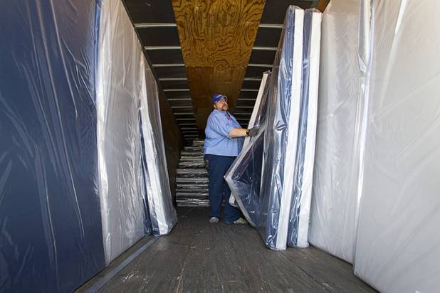 John Ripple, Salvation Army maintenance assistant, unloads mattresses from a truck during a donation of 200 new mattresses at the Salvation Army shelter on Owens Avenue Monday, July 30, 2012. The donation was the launch of Project Beds for America by WorldBed. 