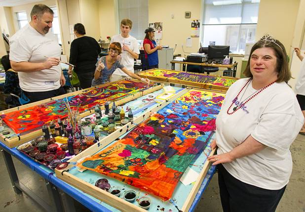 Opportunity Village client Clarissa poses after completing a hand-painted silk scarf with volunteers from the Cosmopolitan at the Opportunity Village Engelstad Campus on South Buffalo Drive Monday, July 29, 2012. Corporate volunteers come to the campus once a month to work with clients.